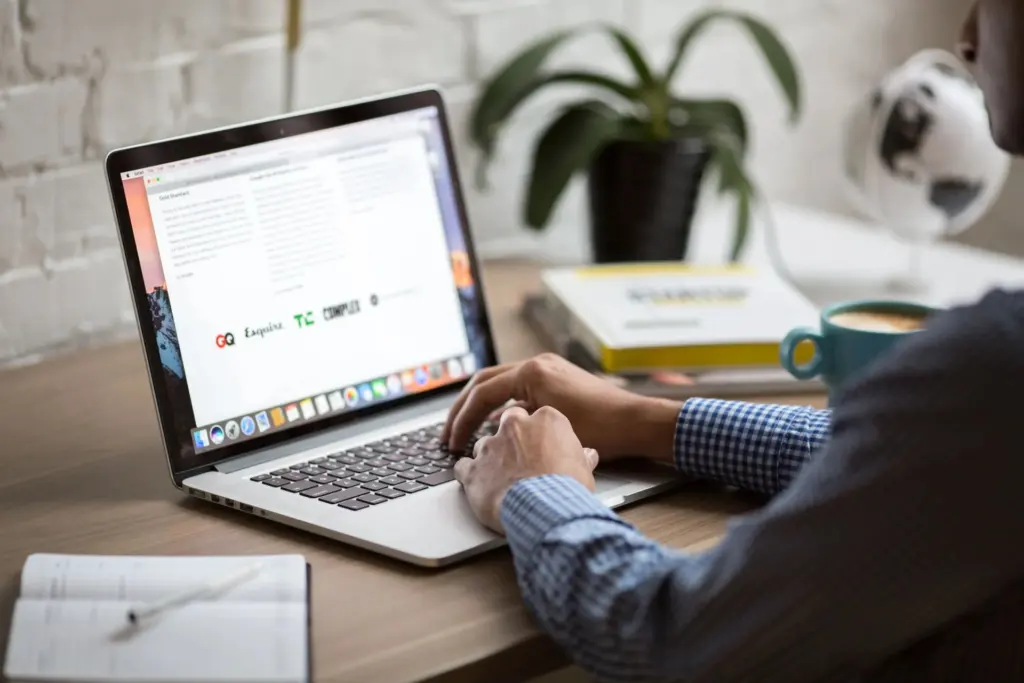 A person reading a blog on a laptop in a bright home office